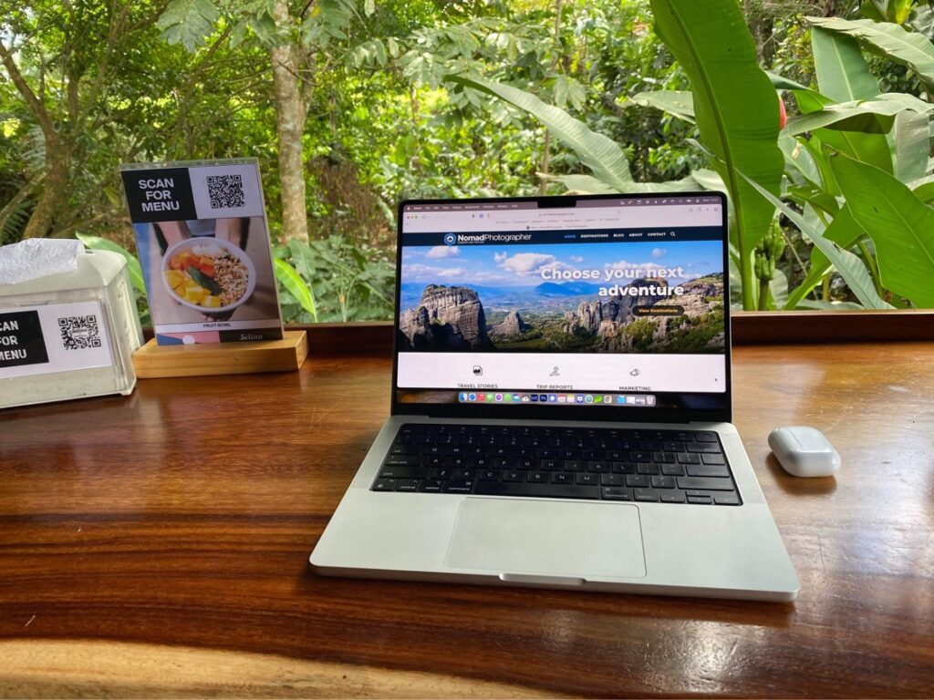 a laptop on a table with a jungle behind in La Fortuna, Costa Rica