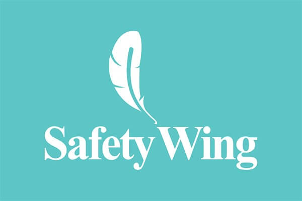 The image shows a light blue background with a white feather above the text "Safety Wing," which is written in capitalized, serif font.